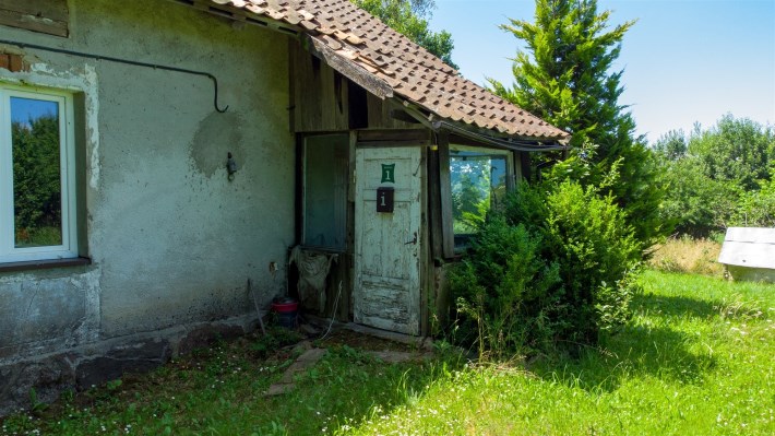 Drzwi wejściowe do domu w Sówkach z tabliczką nume